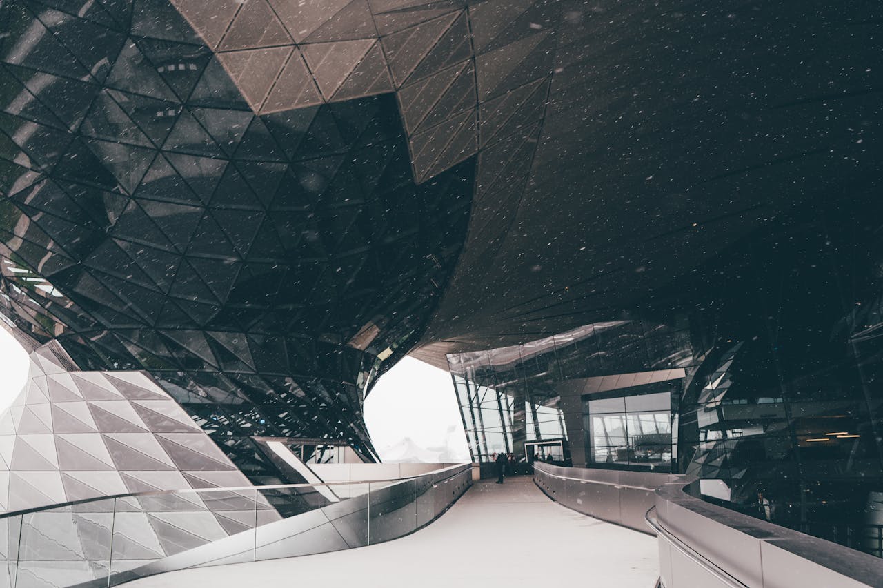 Futuristic architectural design with snow in Munich, showcasing glass and geometric features.