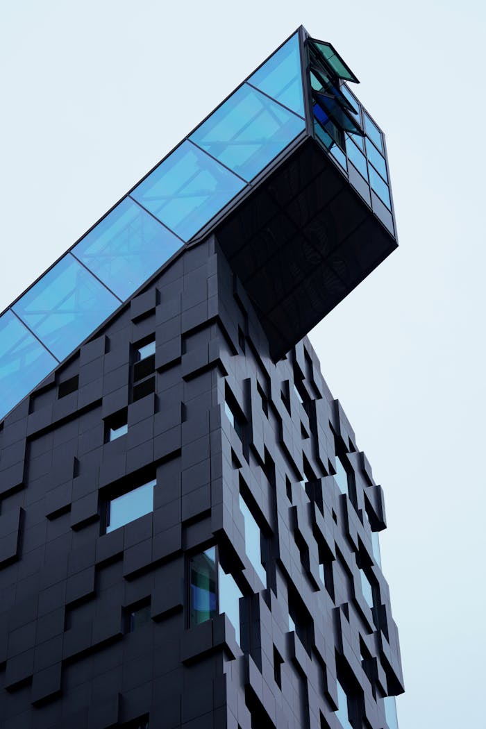 Low angle view of a modern building with glass extension in Oslo, showcasing unique architecture.