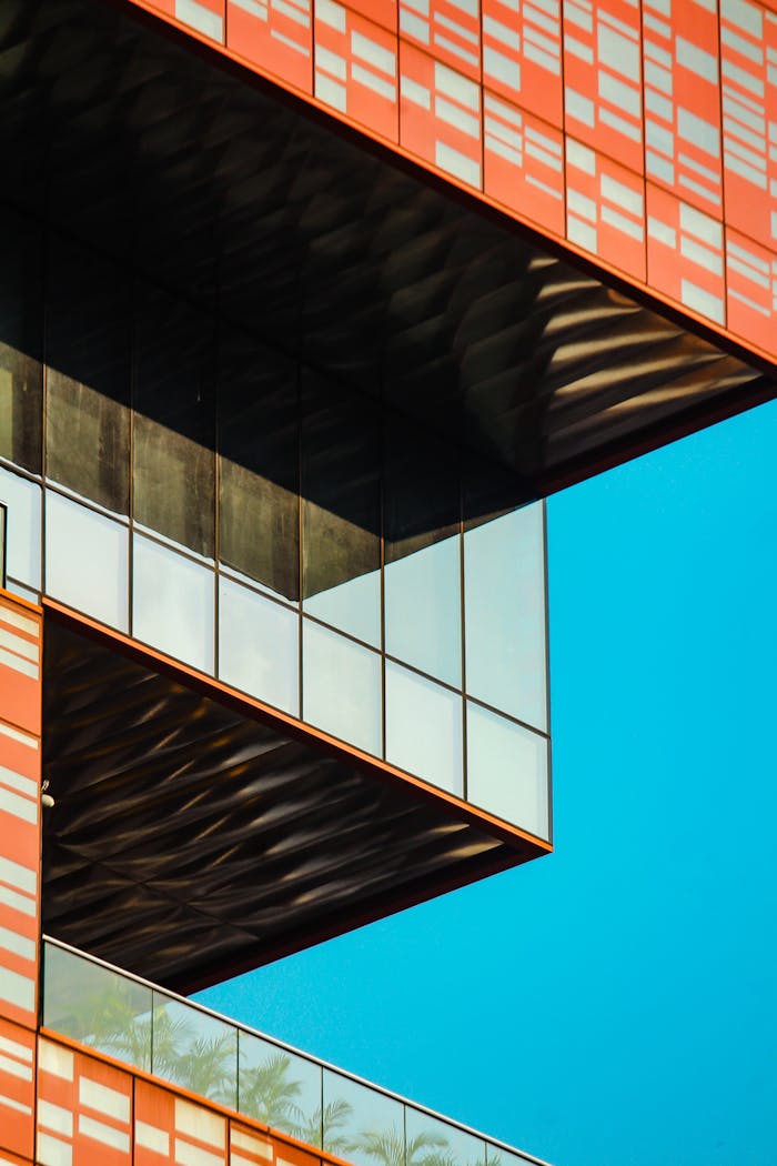 Striking modern architectural design with geometric patterns and bold colors against a blue sky backdrop.