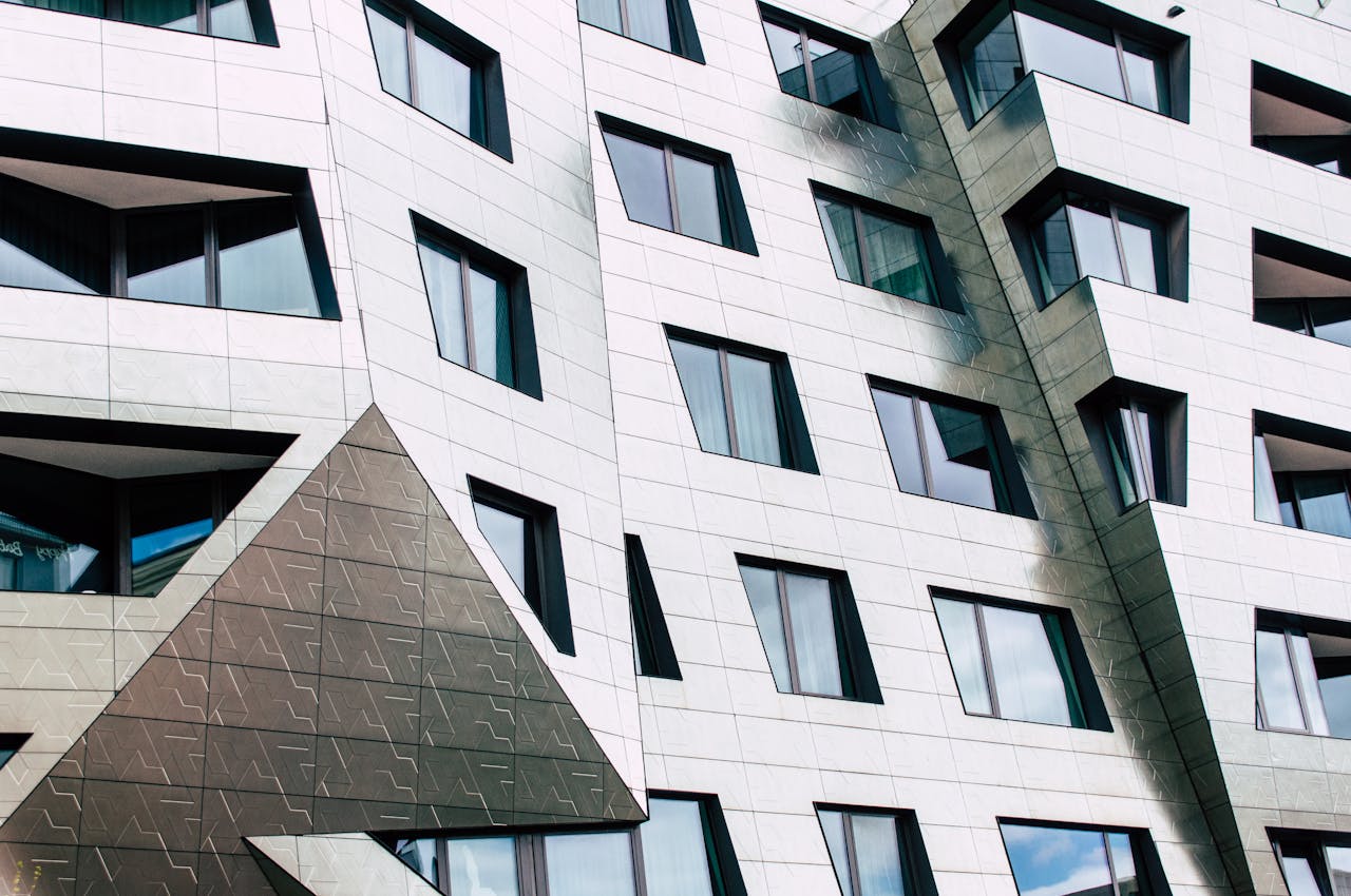 Detailed view of a modern building facade with geometric shapes and reflective windows.