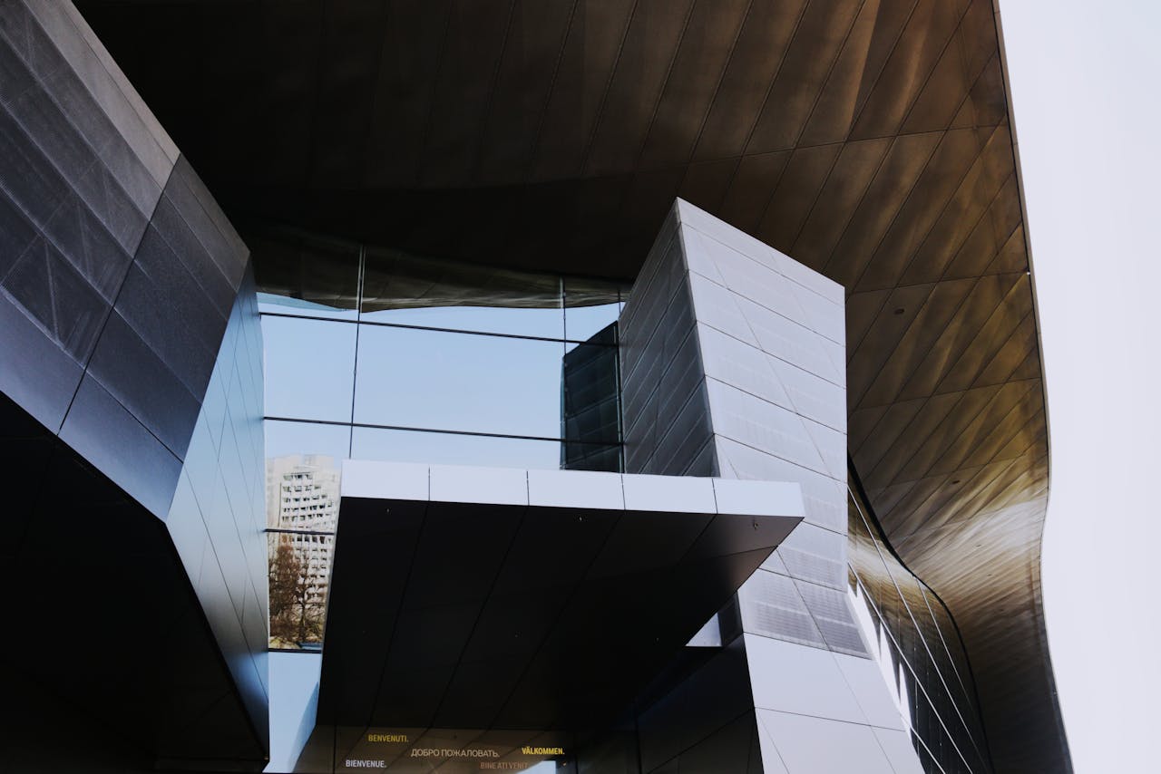Low angle shot of a modern, futuristic building with geometric glass panels in Munich.