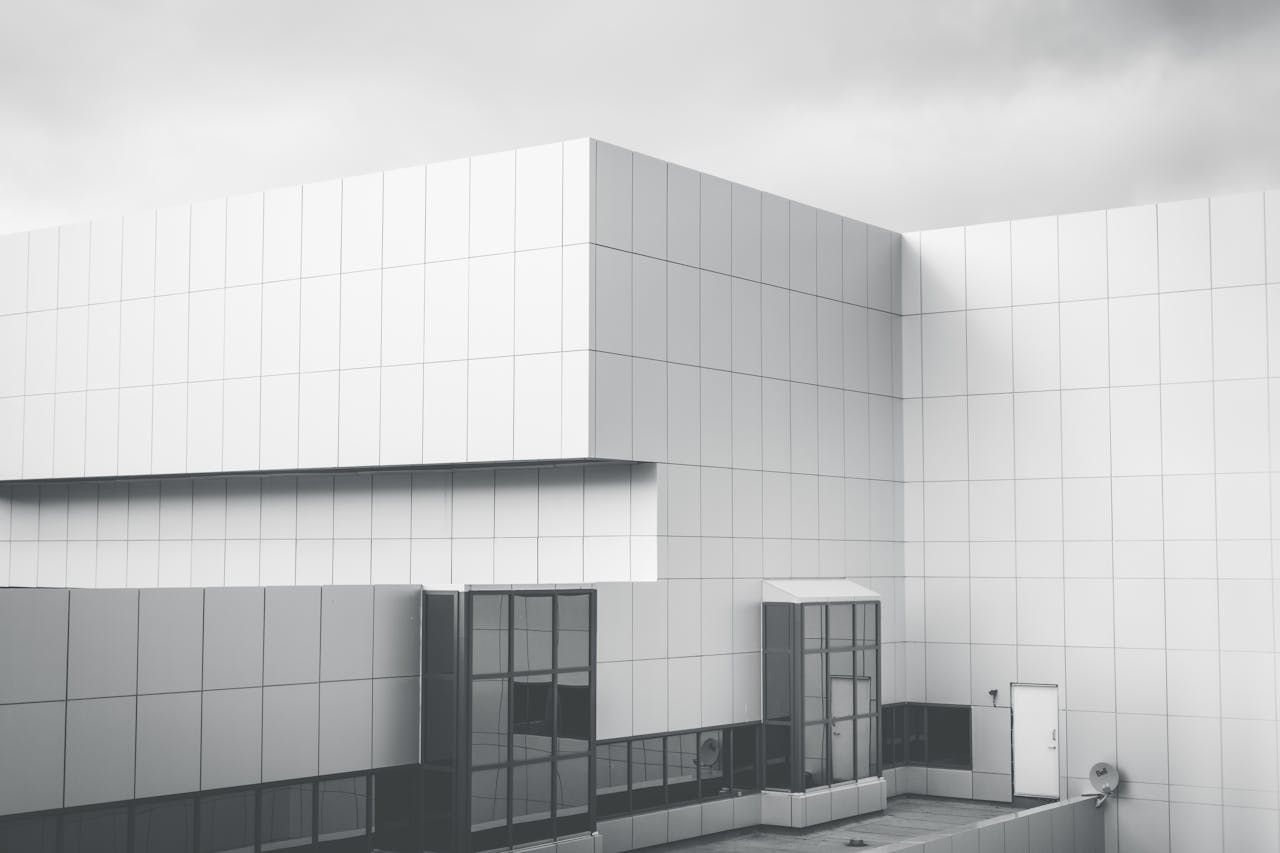 Minimalist white panel facade of a modern building against cloudy sky